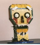 4/97: This is The Head of R&D (RAD) a robot puppet creature I built with Meccano parts for a friend's stage show. The eyes rolled, the mouth moved up and down, and the eyebrows tilted up and down, which gave him an amazing range of facial expression. I worked him through linkages from under a card table, and watched stage happenings on a wirless TV link under the table!
